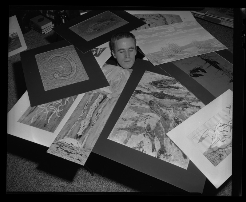 University of Idaho Art student Iain Baxter showing his artwork by laying in a pile of it.