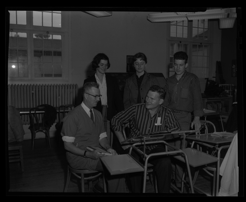 University of Idaho Professor Alf Dunn from the Art Department and students looking over a student's work in Temporary Classroom building #1.