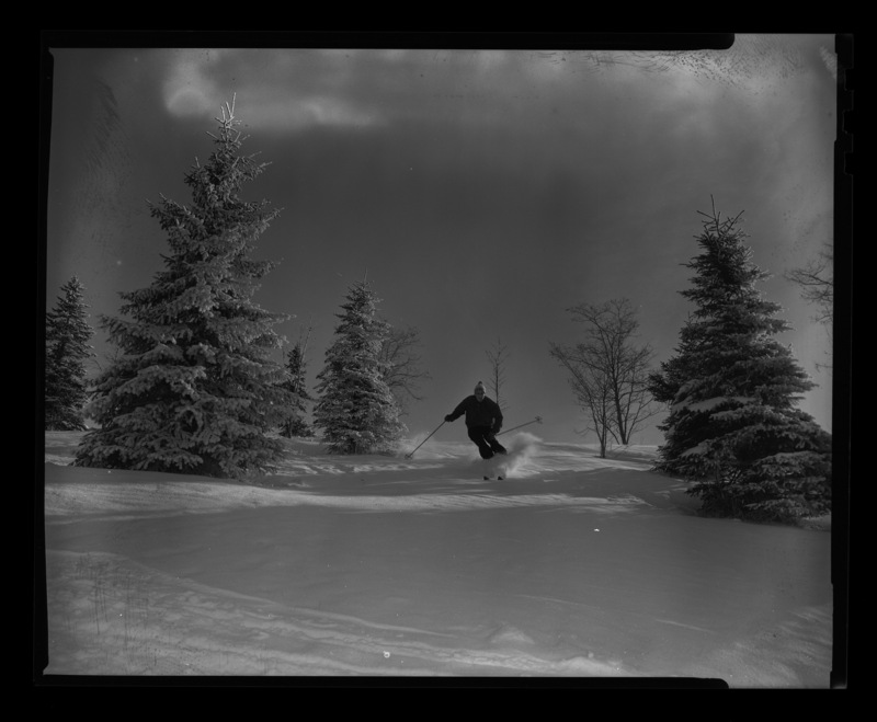 Student Iain Baxter skiing through trees on University of Idaho campus.