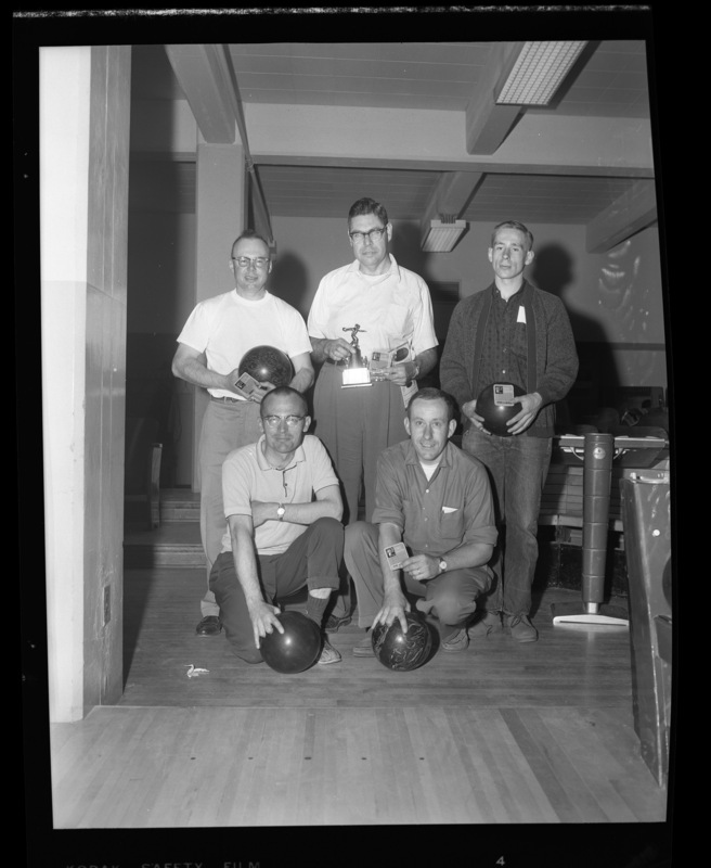 A University of Idaho faculty bowling team poses with their bowling balls and trophies in the SUB bowling alley.