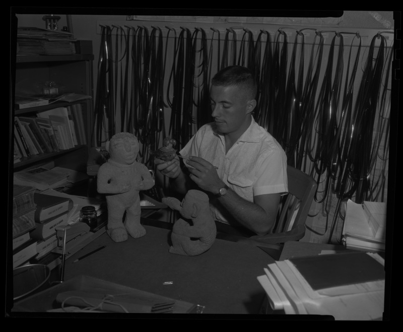 University of Idaho track coach William Sorsby in his office, holding a ceramic bird.