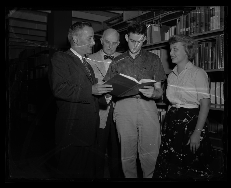 Head of Pacific Division of Dupont Manufacuring meeting with Dr. Erwin Graue, Professor of Business, and two unidentified University of Idaho students in the Library.