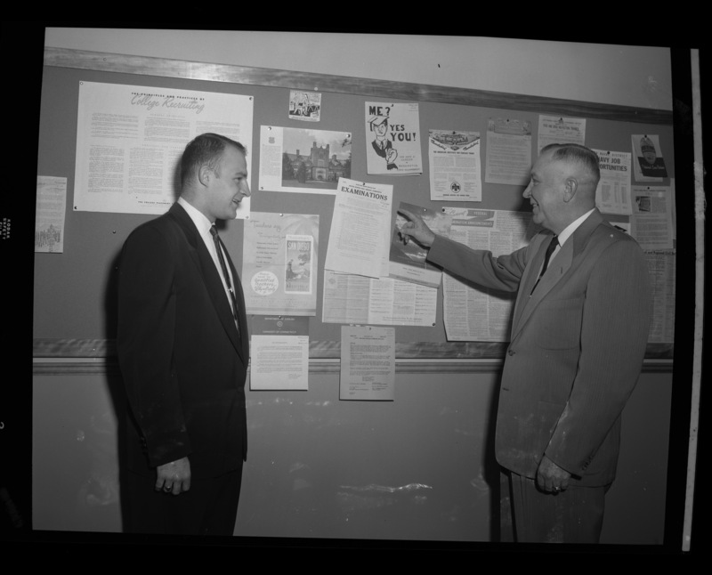 Harlow Campbell, Director of Placement, speaking to a University of Idaho student infront of a bulletin board.