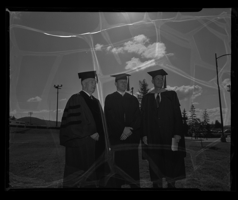 Carl G. Paulsen (left) standing with two unidentified graduates at commencment.