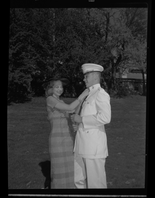 Marine poses with woman for photograph. Old Art Building and Old Gymnasium and Armory can be seen in the background.