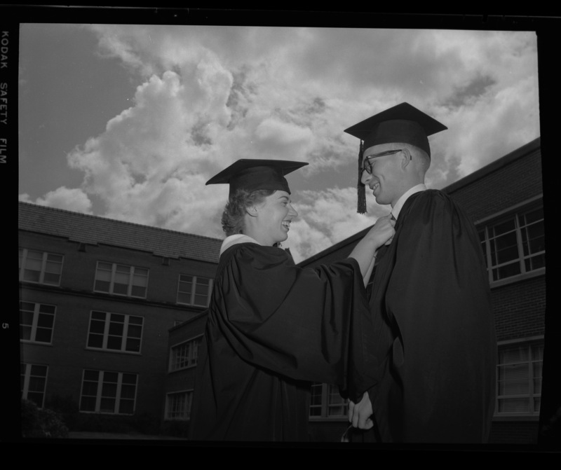 Unidentified graduates outside of commencement. Administration Building and Administration Annex in background.