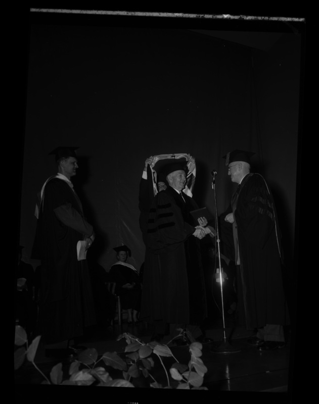 Carl G. Paulsen (center) is hooded and receives an honorary Doctorate of Science degree on stage with Dean of Engineering, Alan Janssen (left), and President Theophilus (right) at commencment.