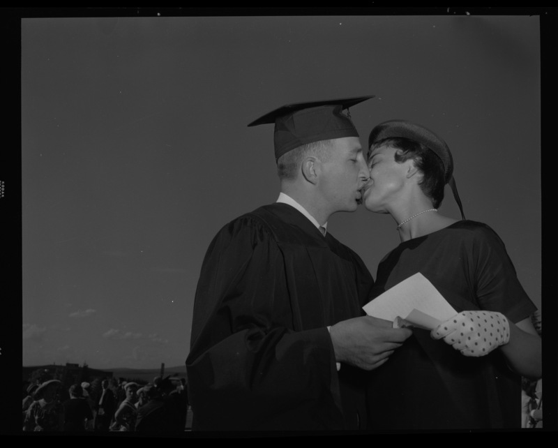 Graduate kissing a woman outside of Memorial Gym on commencement day.