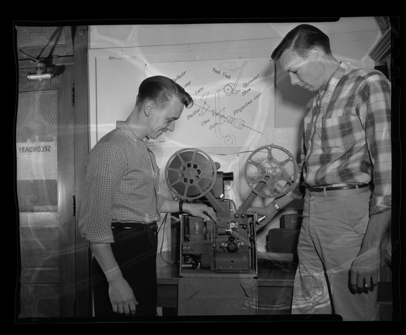 Students from the Audio-Visual Aids class examining a Victor Triumph Movie Projector Animatophone.