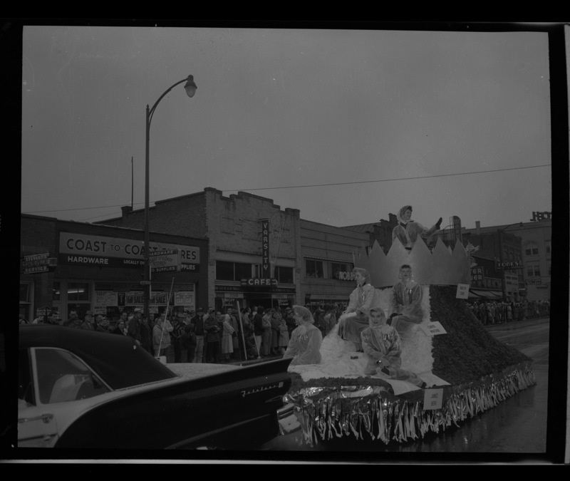 1957 Homecoming queen Marilyn Crane waves to the crowd lining Main Street with her court ladies (l-r) Jan Novak, Shirley Henriksson, Janice Berg, and Carol Wachal during the homecoming parade.