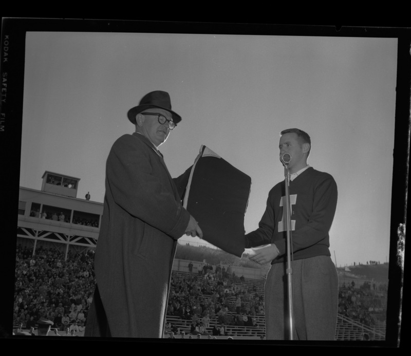 Wanek Stein (left) is named "Vandal Booster of the Year" and presented with an "I" blanket by Robert Hansen, president of the "I" Club during halftime at the 1959 homecoming game.