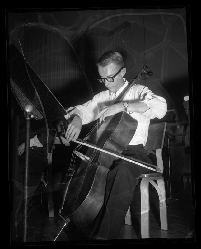A cello player in the symphony orchestra practices with the group.