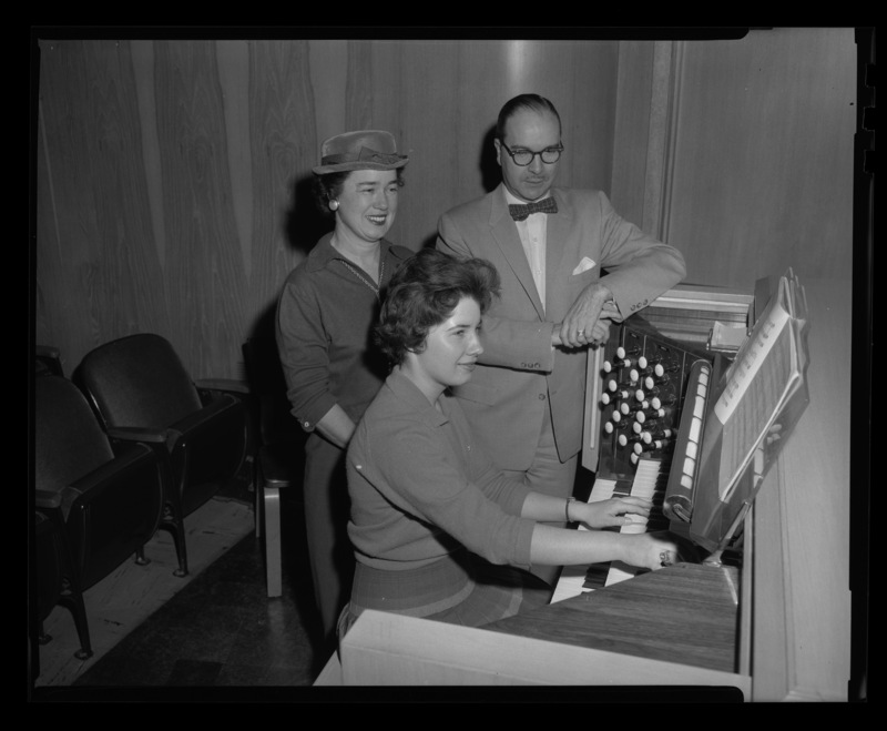 Organist Kathleen Irwin plays the Jewett Memorial Organ while Dean of Music, Hall Macklin, and her mother, Mrs. Claud Irwin, watch her play.