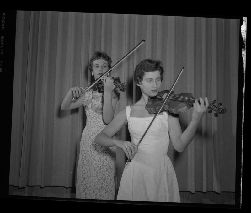 School of Music students Georgia Finch and Sally Maddocks posing with their violins.