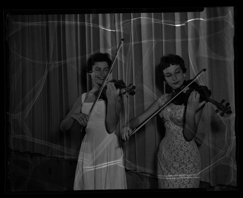 University of Idaho students Sally Maddocks and Georgia Finch posing with their violins.
