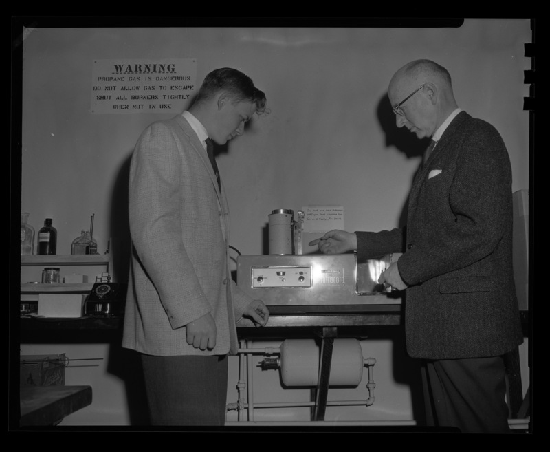 Student Keith Watenpaugh and chemistry Professor Malcom Renfrew examine a spectrophotometer.