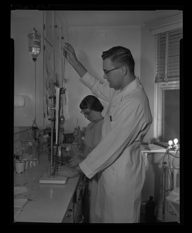 Husband and wife team William Mitchell, pre-Medicine, and Carolyn Dempsey Mitchell, Bio-Chemistry, work together in a laboratory at Gritman Hospital.