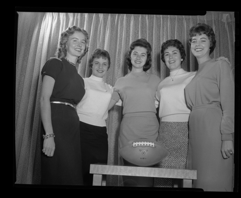 The five finalists for 1959 Homecoming Queen pose with a football. From left to right: Trenna Atchley, Lynne Shelman, Nadine Talbott, Carolyn Blackburn, and Phyllis Weeks.