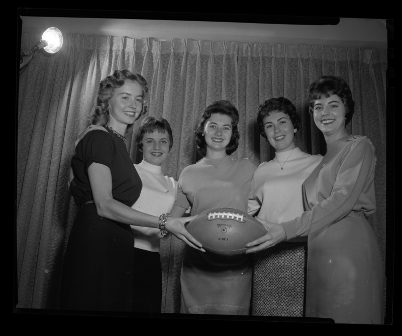 The five finalists for 1959 Homecoming Queen pose with a football. From left to right: Trenna Atchley, Lynne Shelman, Nadine Talbott, Carolyn Blackburn, and Phyllis Weeks.
