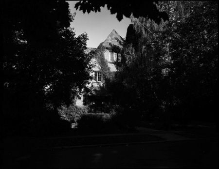 A photograph of the Pi Beta Phi sorority house through foliage.