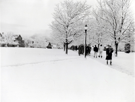 Students walking through a snowy landscape on campus.