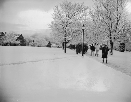 Students walking through a snowy landscape on campus.