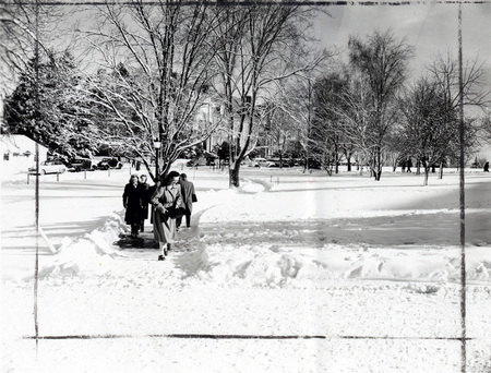 Students walking through a snowy landscape on campus.