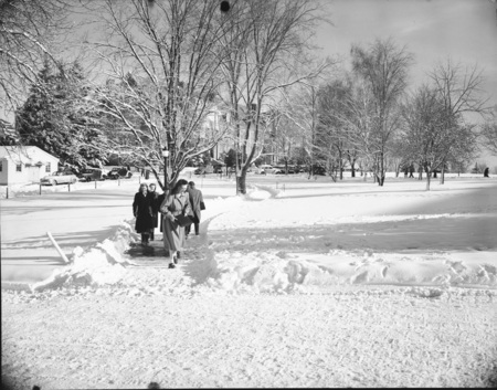 Students walking through a snowy landscape on campus.
