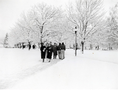 Students walking through a snowy landscape on campus.