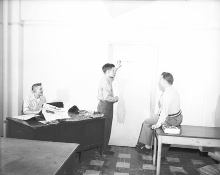Staff members place an Idaho Argonaut sign on a door in the student newspaper's office in the Student Union Building.