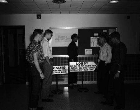 A photograph of new students waiting in a lobby.