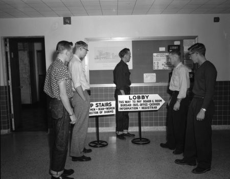 A photograph of new students waiting in a lobby.