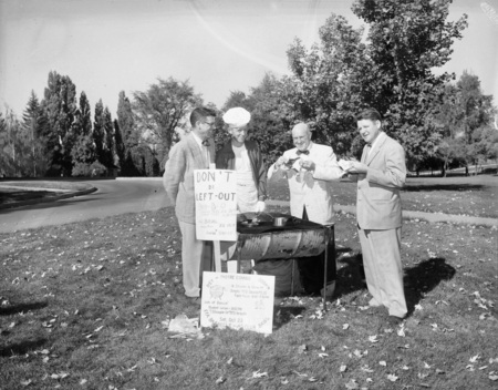 A group photo of University President Theophilus enjoying barbeque with a group of men.