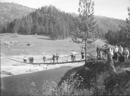 Students cross a rope bridge during geology field trip.