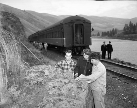 Students use their rock hammers to get a sample from a boulder.