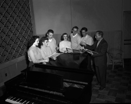 Choir students practice from song books.