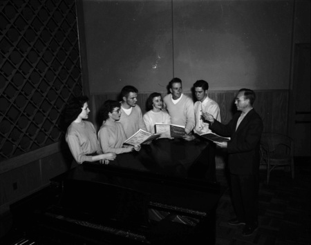 Choir students practice from song books.