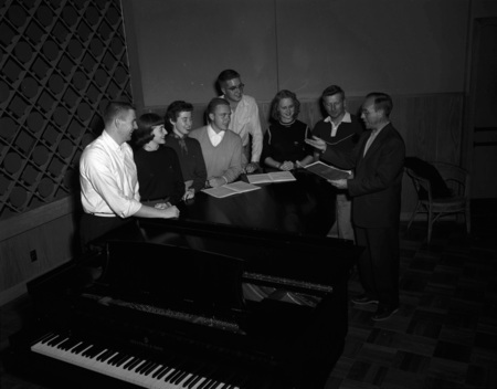 Choir students practice from song books.