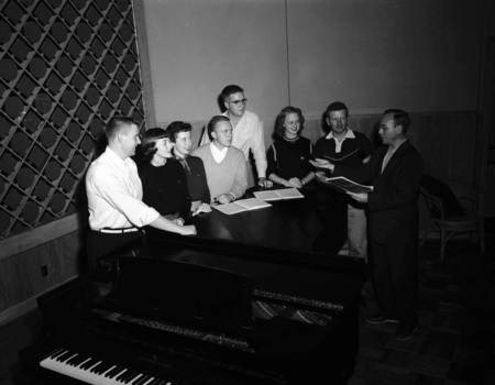 Choir students practice from song books.