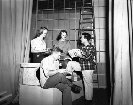 Choir students practice from song books.