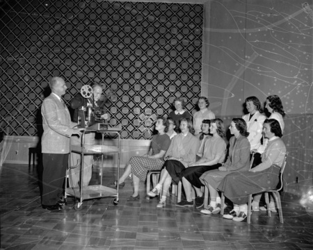 Students sit as faculty sets up a projector.