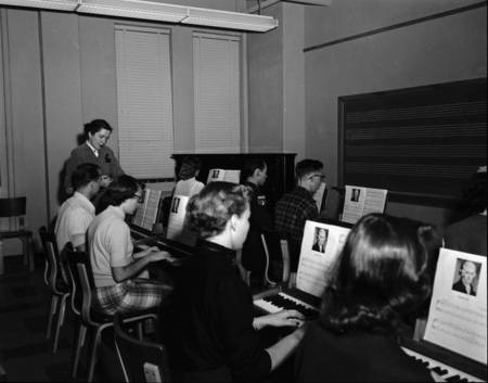Students practicing piano in class.
