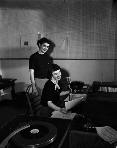 KUOI announcers reading a script.