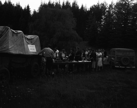 Students grab food at the chuck wagon in the woods.