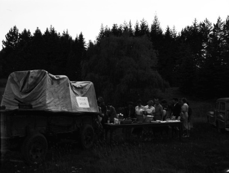 Students grab food at the chuck wagon in the woods.
