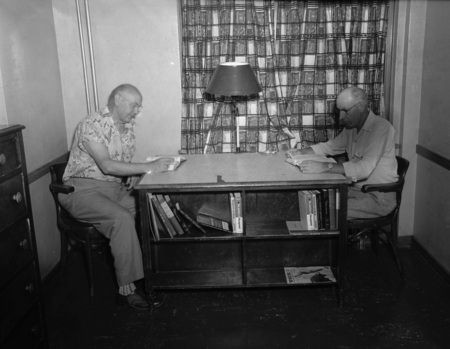 Two unidentified men reading during the Public Utilities Conference.