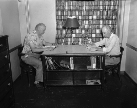 Two unidentified men reading during the Public Utilities Conference.