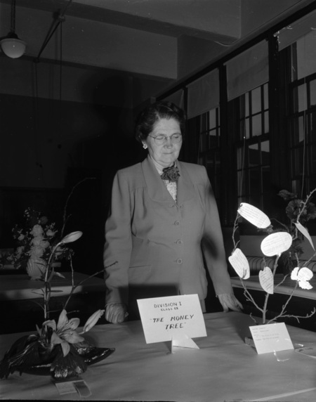 Mrs. Nelson examining floral arrangements.
