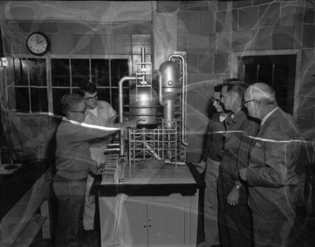 College of Engineering students Frank Delavan, LeRoy Murray, Dennis Gray, and Perry Christianson, with Professor Hindle, examining equipment.