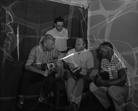 Students holding cameras while at a summer school photography workshop.